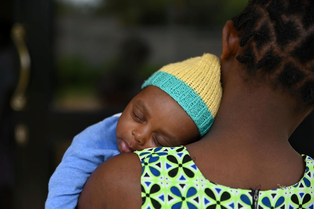 Back of lady showing baby resting on her shoulder