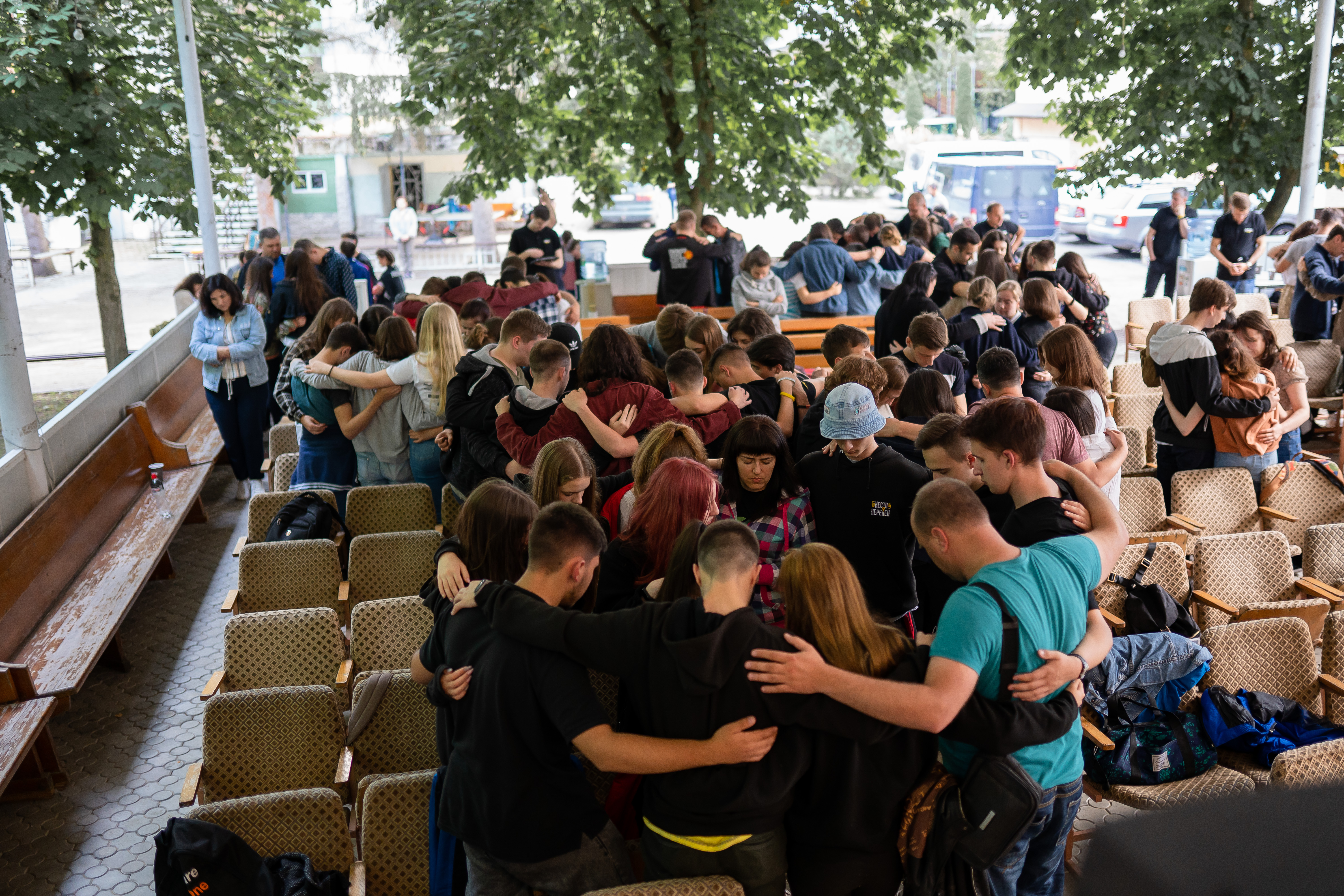 A group of young people, embracing each other in a circle. 