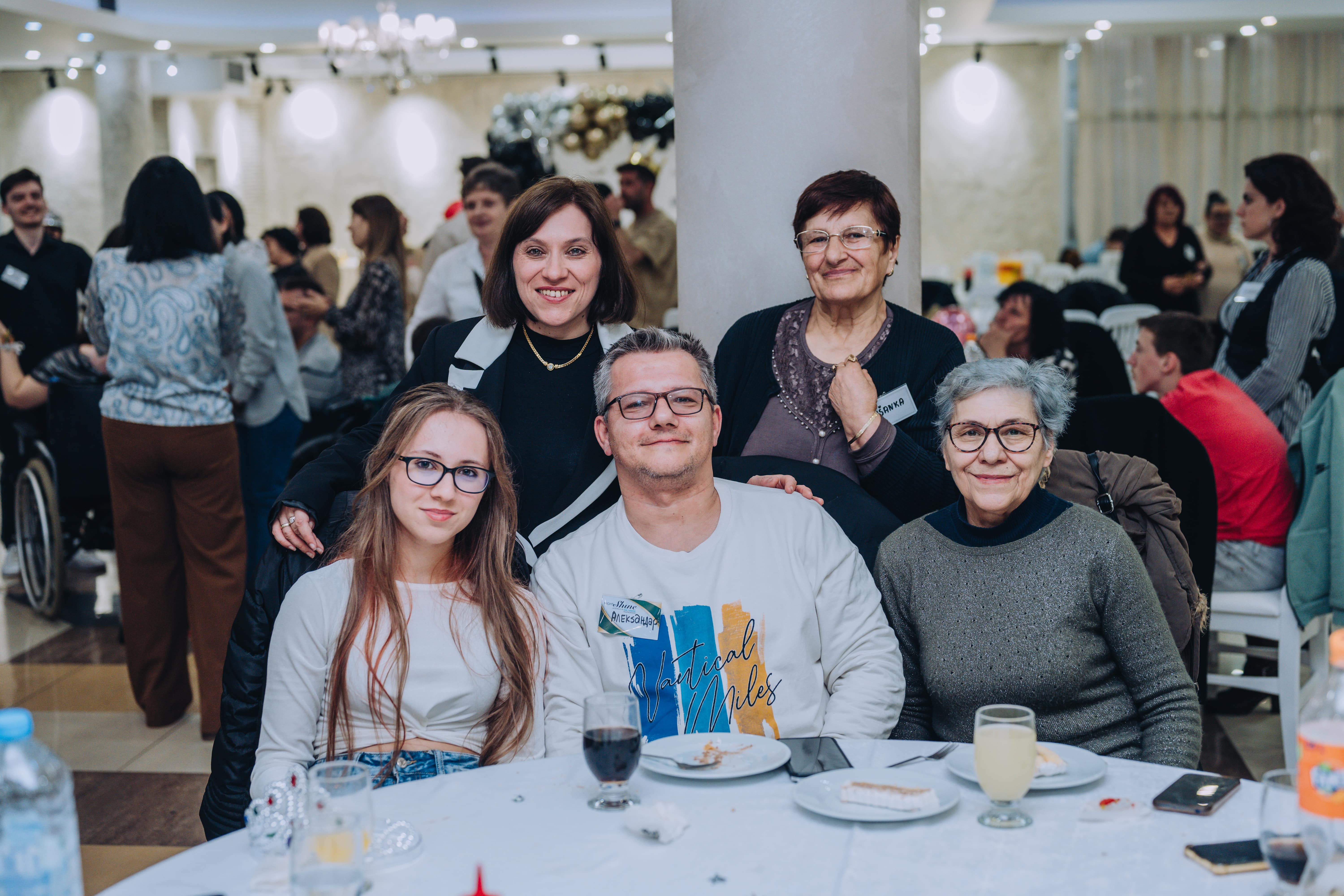 A group of people ,all mixed ages, smiling for the camera at a church event. 