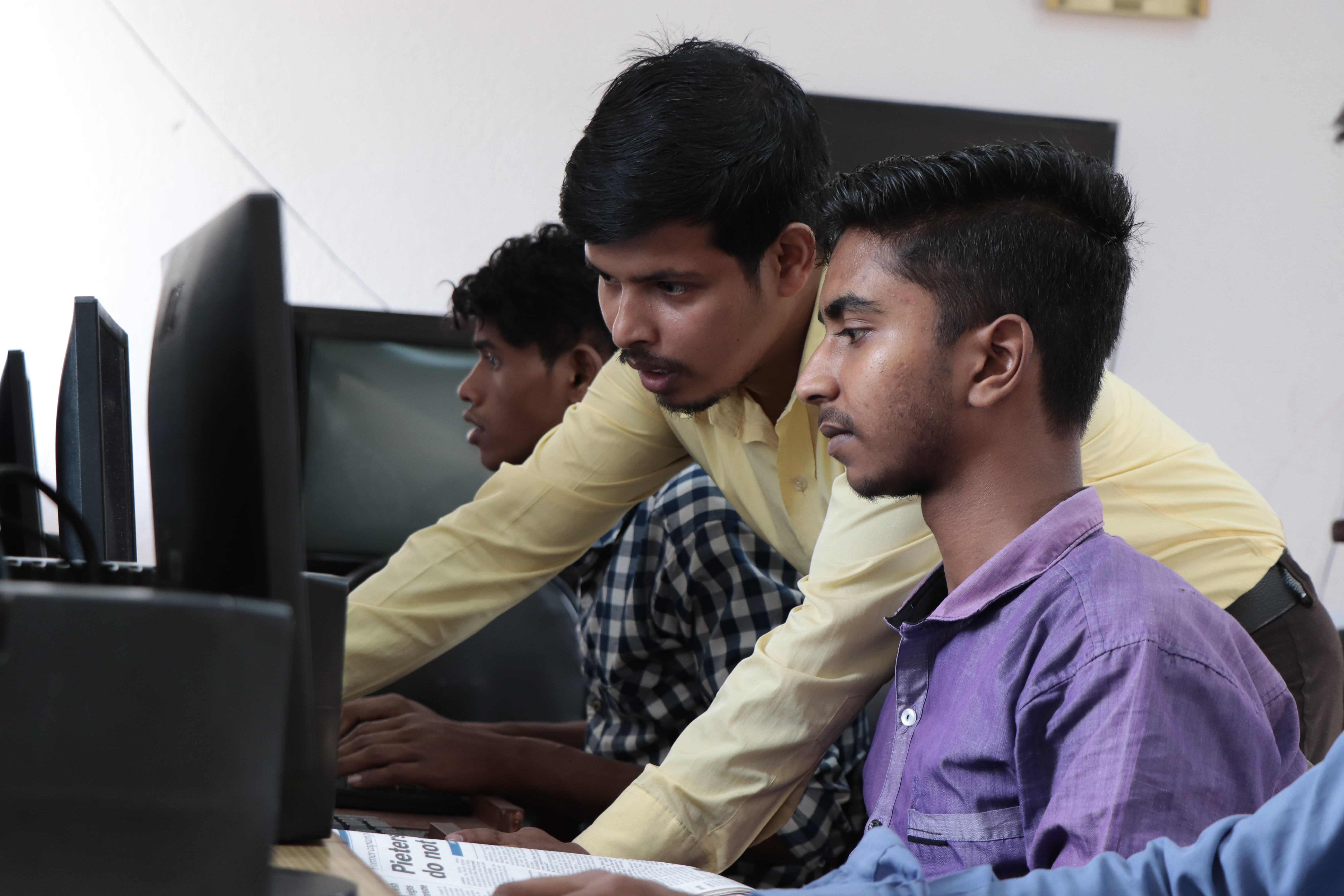 two young men working at a computer 