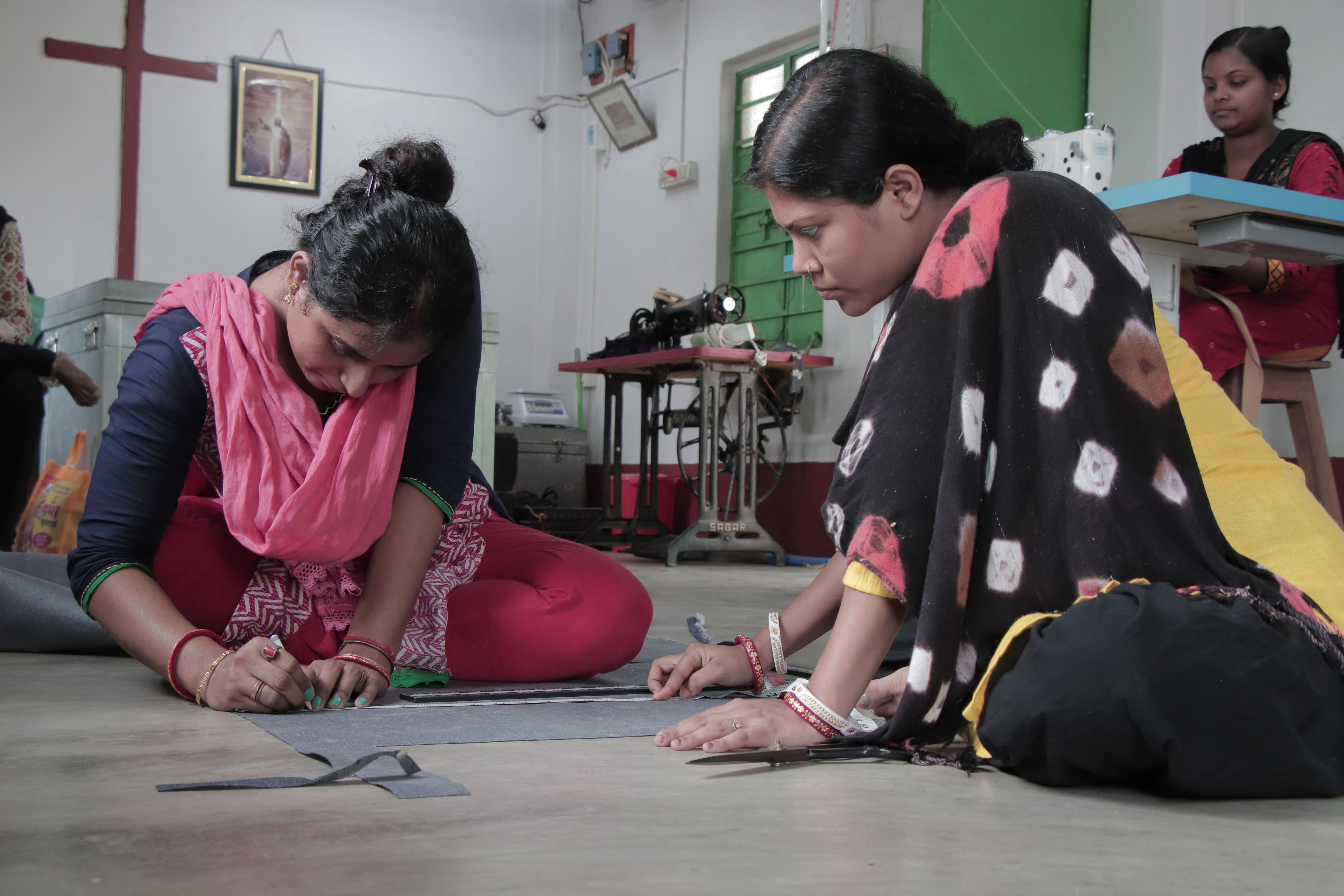 two women working together to design a garment. 