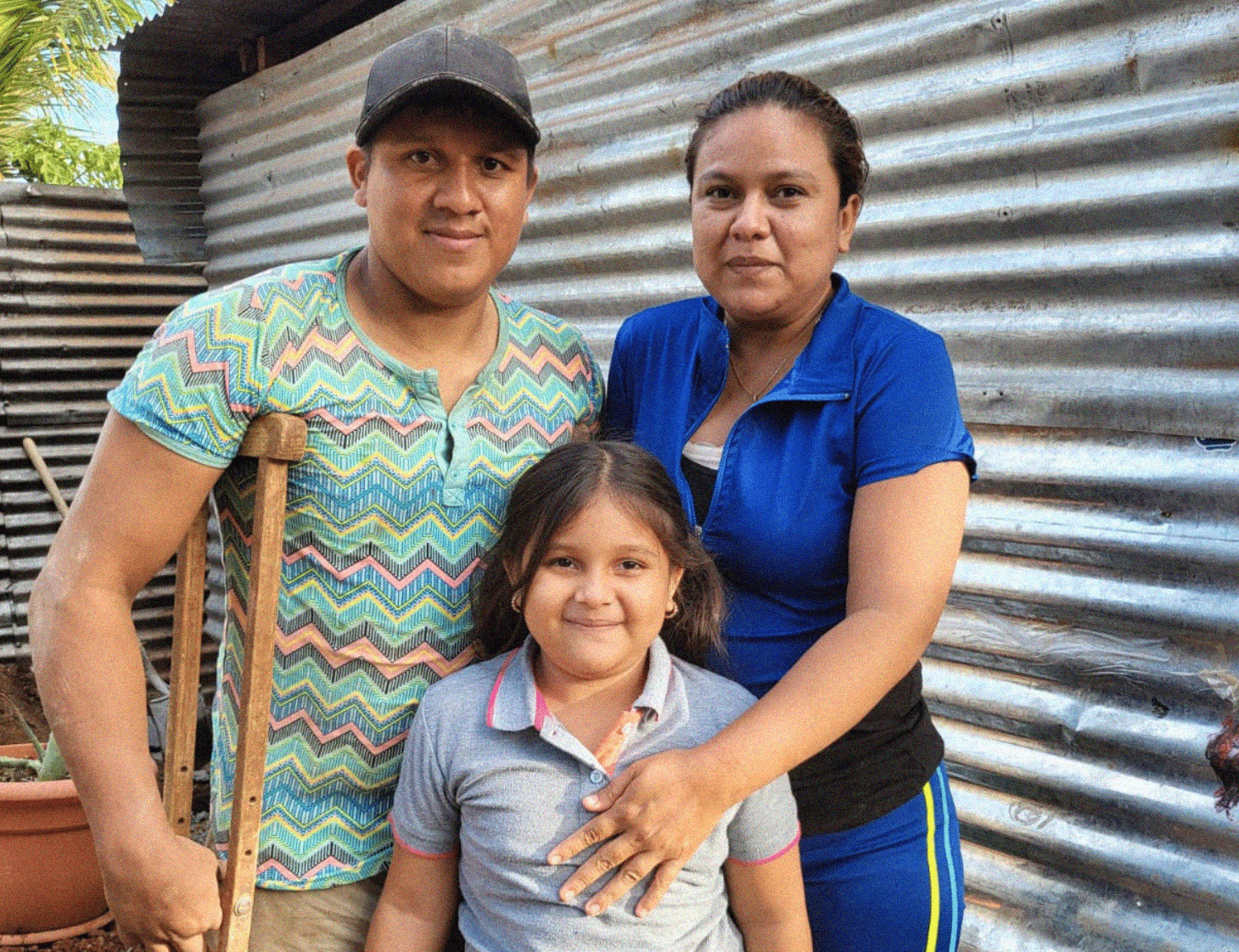 A young family smiling at the camera 