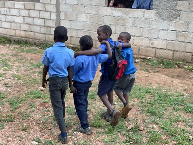 Four children embracing each other at school.