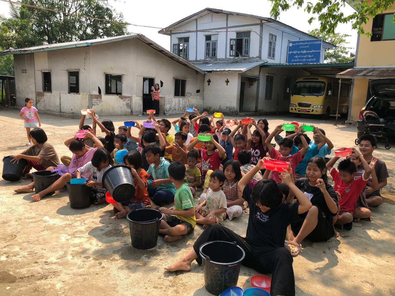 A large group of children sitting outside