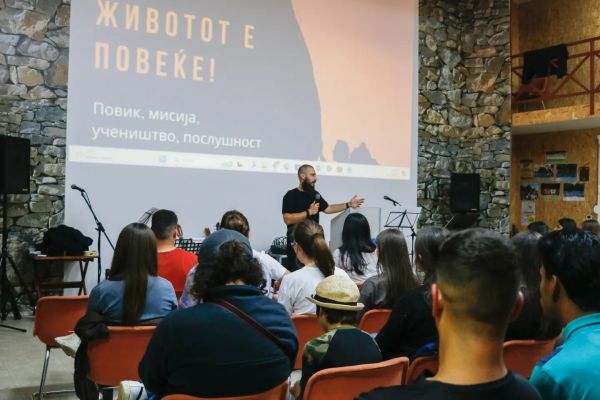 Young people listening to a speaker during an ECNM youth conference