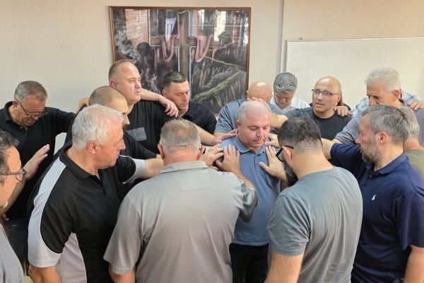 Leaders lay hands and pray together for the new president of the Evangelical Church in North Macedonia