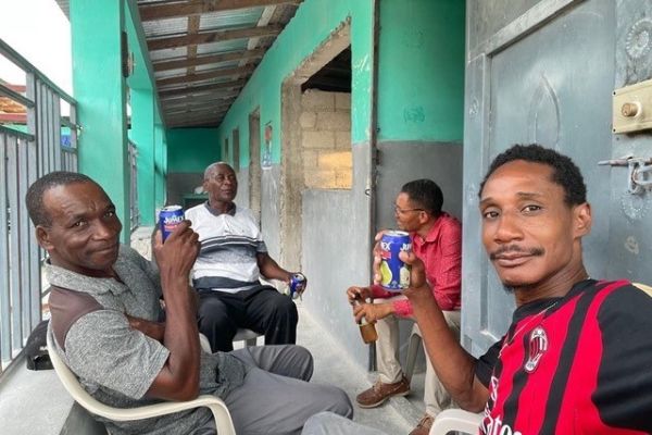 Four members of the PiFò Haiti school team meeting outside a school building