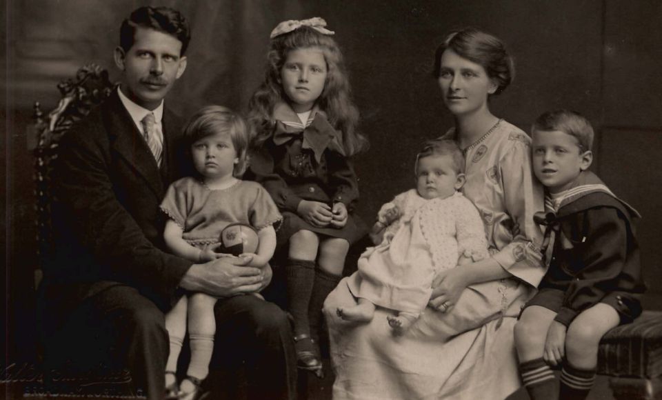 A vintage family portrait featuring a mother, father, and their four young children.