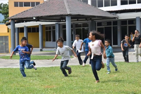 Children running together during an outdoor activity at the Potter’s House in Guatemala