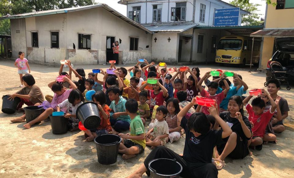 A large group of children sitting outside