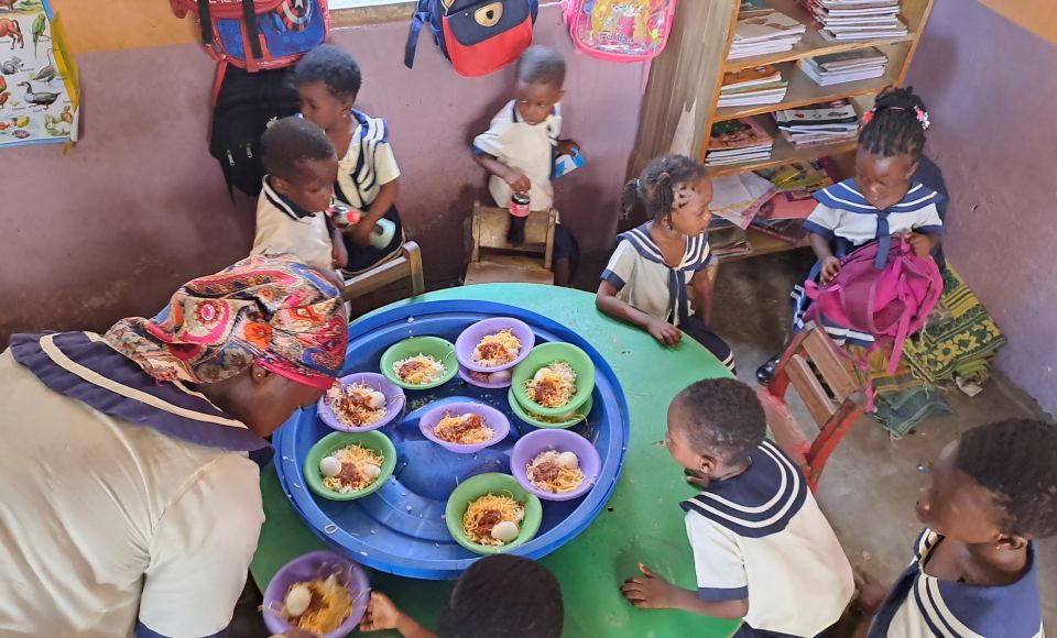 A group of young children sharing food around a table at school 