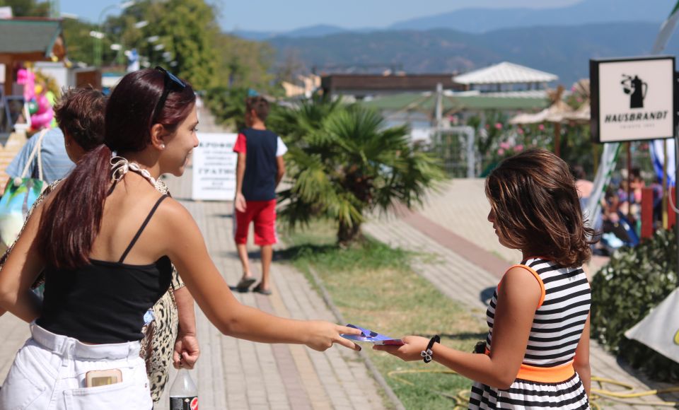 A young woman handling a leaflet to another woman 