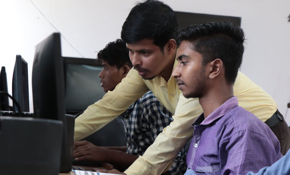 two young men working at a computer 