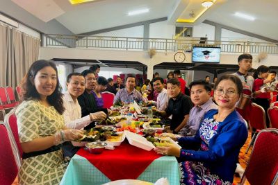 A group of young ladies smiling for the photo over dinner.