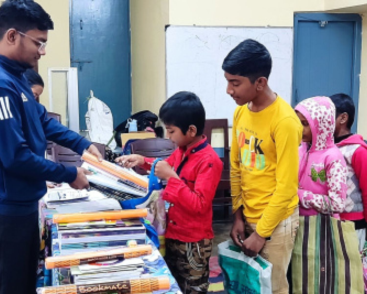 young children looking at a book together. 