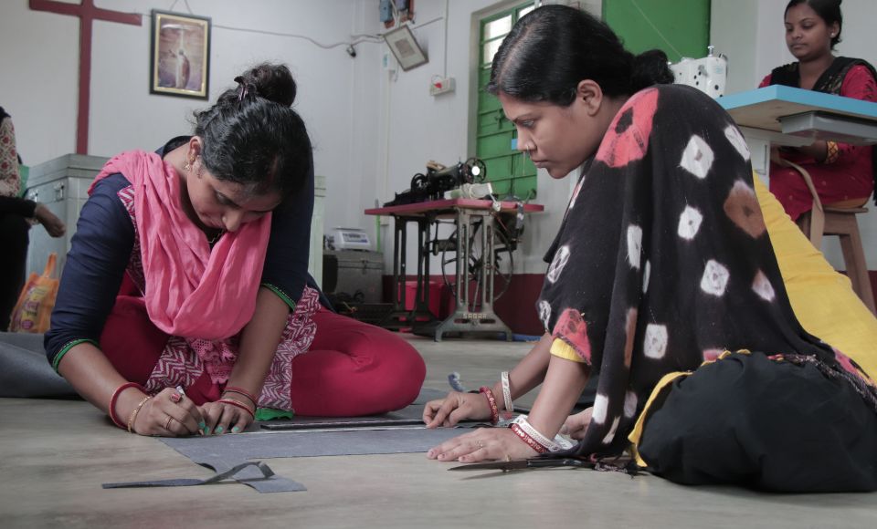 two women working together to design a garment. 