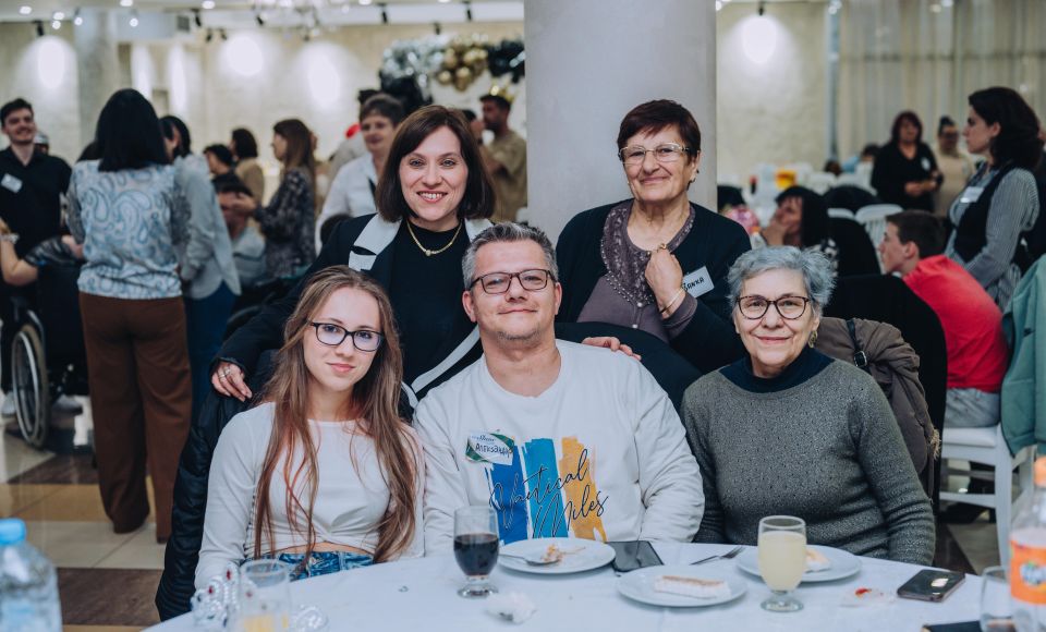 A group of people ,all mixed ages, smiling for the camera at a church event. 